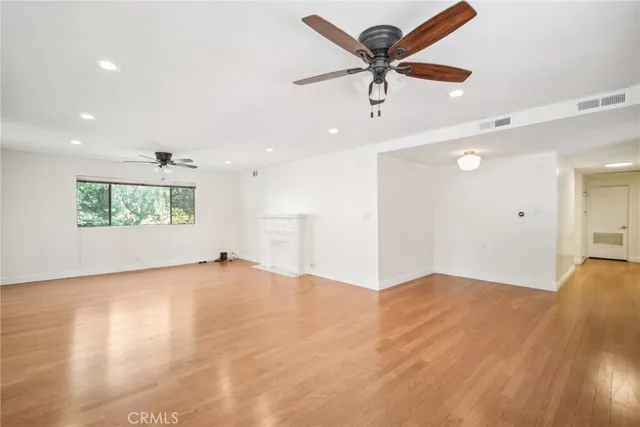 an empty room with fan and windows