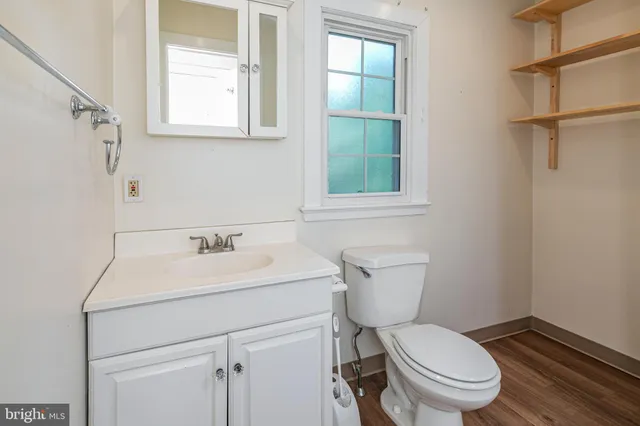 a bathroom with a toilet sink vanity and mirror