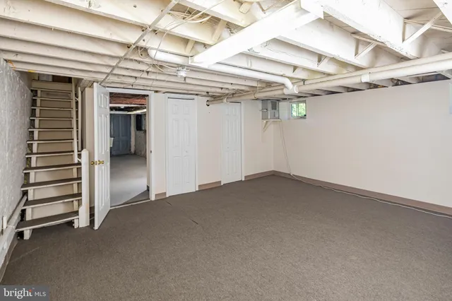 a view of an empty room with a white car parked
