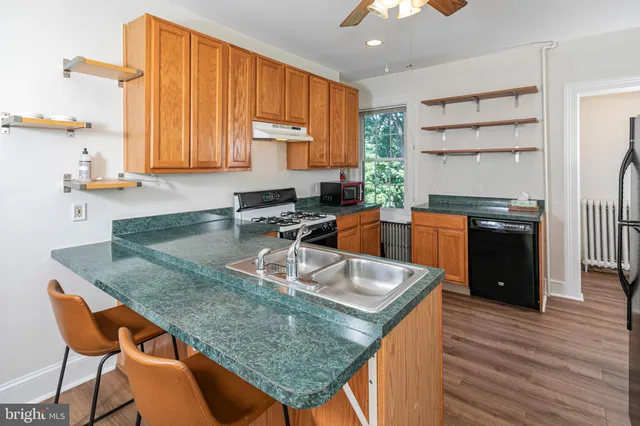 a kitchen with granite countertop a sink a counter top space and cabinets