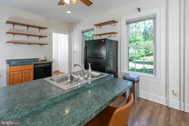 a kitchen with kitchen island granite countertop a sink cabinets and window