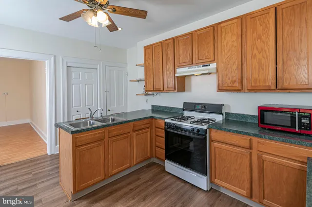 a kitchen with stainless steel appliances granite countertop a stove a sink and a microwave