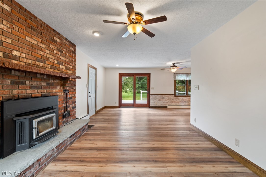 34 Kehner Road Mogadore, OH 44260 - Photo 4 of 40 Brick fireplace with stone hearth, wood-finish flooring, ceiling fans, recessed lighting, and sliding glass door
