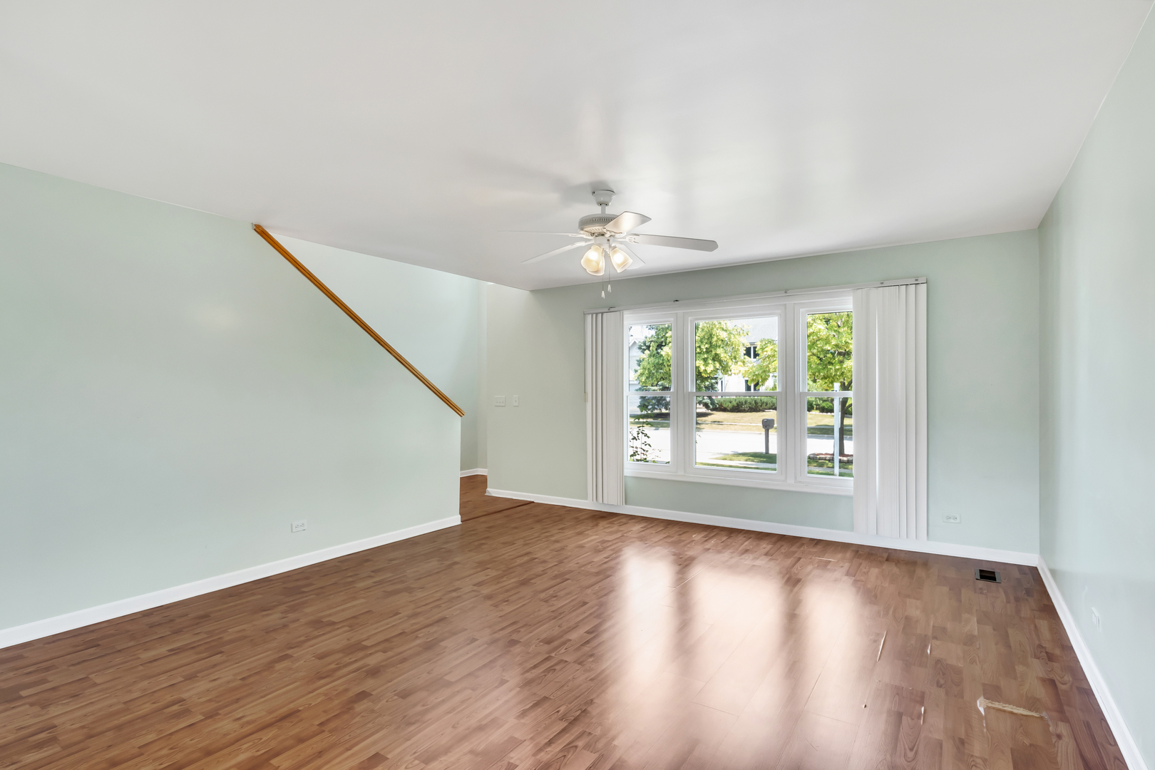 700 Greenview Lane Wheeling, IL 60090 - Photo 4 of 26 an empty room with wooden floor fan and windows