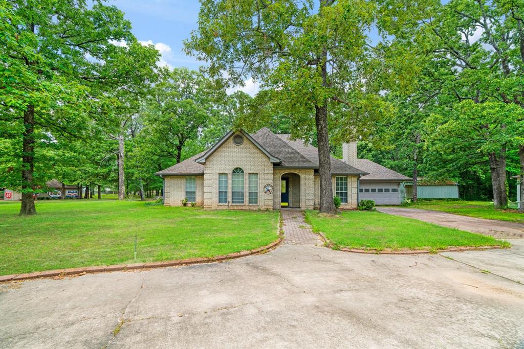 455 Timber Lakes Drive Powderly, TX 75473 - Photo 1 of 18 a front view of a house with a yard and trees