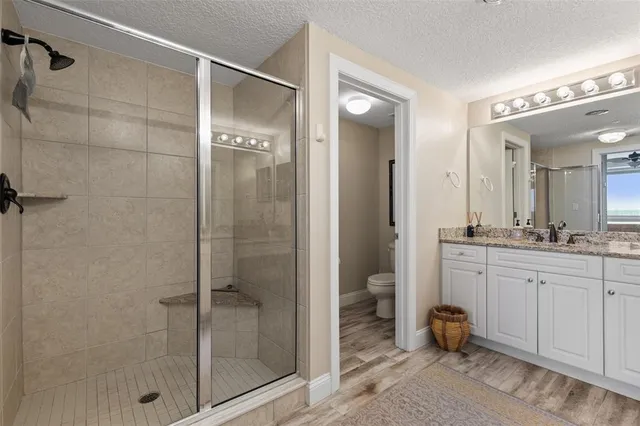 a bedroom with a bed and dresser with wooden floor