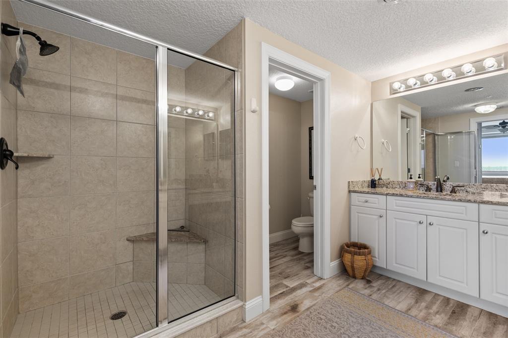 60 Surfview Drive, Unit 502 Palm Coast, FL 32137 - Photo 23 of 63 a bathroom with a granite countertop sink a mirror and a shower
