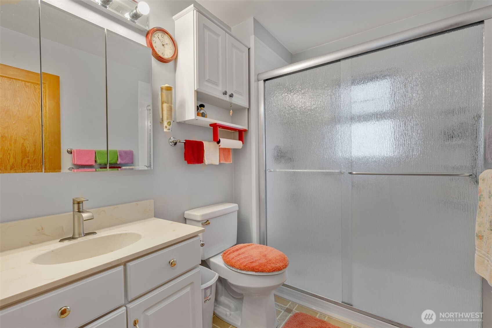929 Northwest 59th Street Seattle, WA 98107 - Photo 19 of 38 a bathroom with a sink toilet vanity and shower