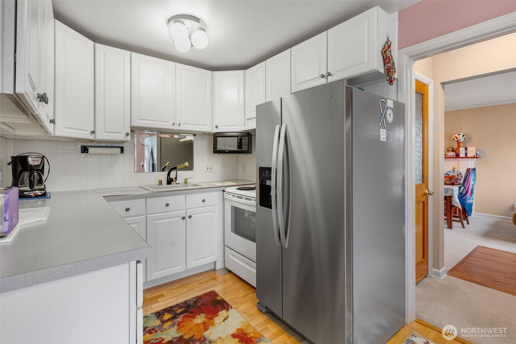 929 Northwest 59th Street Seattle, WA 98107 - Photo 10 of 38 a kitchen with white cabinets and refrigerator