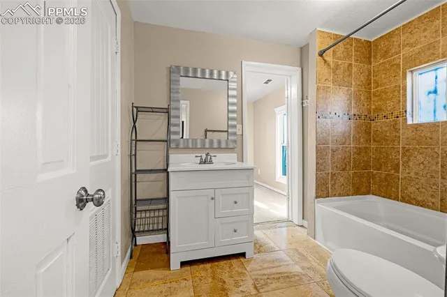 a bathroom with a tub sink toilet and shower