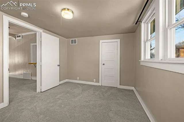 an empty room with windows and closet