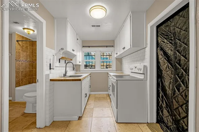 a kitchen with cabinets and wooden floor