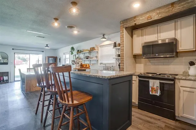 a kitchen with cabinets and chairs