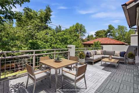 an outdoor sitting area with furniture and wooden floor