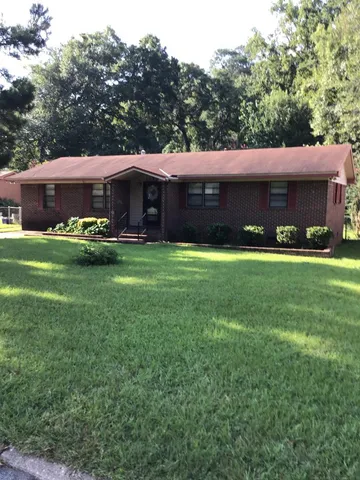 a view of a house with a garden and sitting area