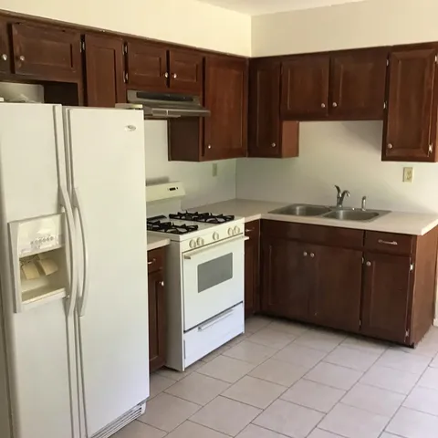 a kitchen with a white stove top oven and cabinets