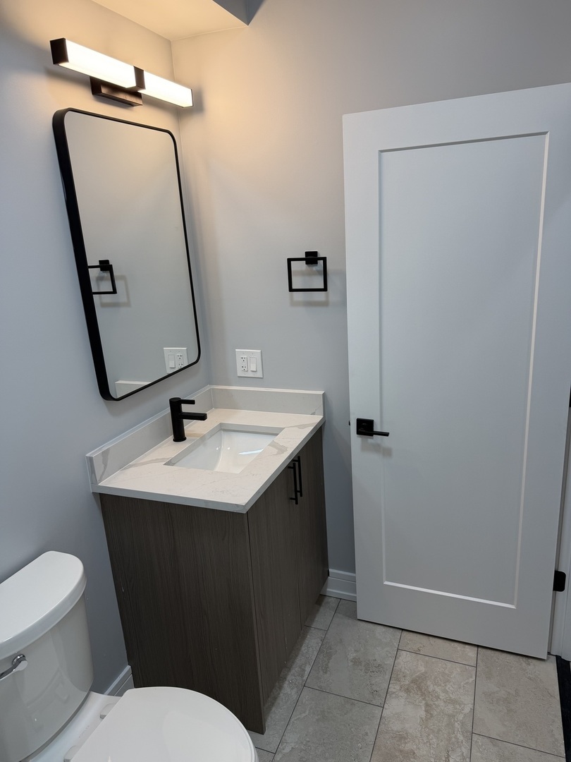 2622 West Adams Street, Unit 3 Chicago, IL 60612 - Photo 18 of 26 a bathroom with a sink a toilet and mirror
