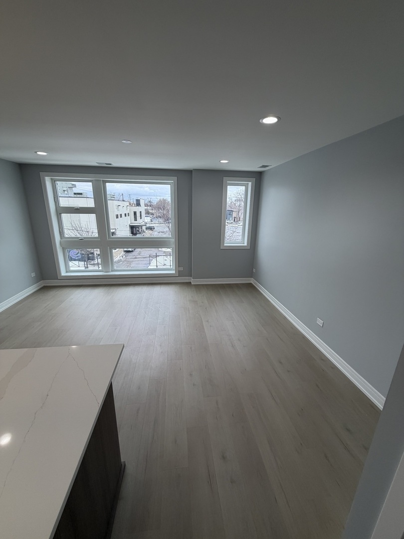 2622 West Adams Street, Unit 3 Chicago, IL 60612 - Photo 8 of 26 an empty room with wooden floor and windows