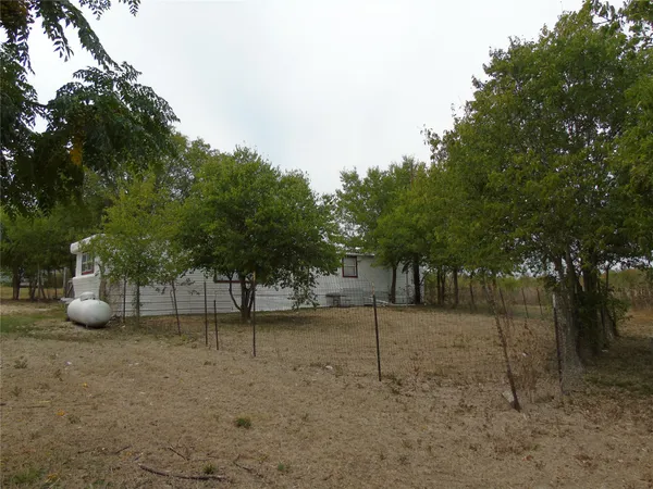 a view of a field with trees in the background