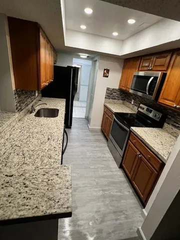 a kitchen with stainless steel appliances granite countertop a stove and a sink