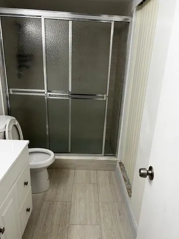 a bathroom with a toilet and a shower