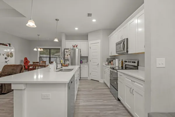 a kitchen with stainless steel appliances a sink dishwasher stove refrigerator and cabinets