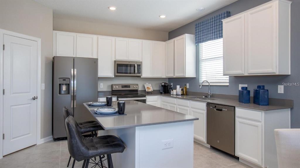 643 Grove Street Winter Haven, FL 33881 - Photo 4 of 16 a kitchen with stainless steel appliances granite countertop a stove top oven a sink dishwasher a refrigerator and cabinets with wooden floor