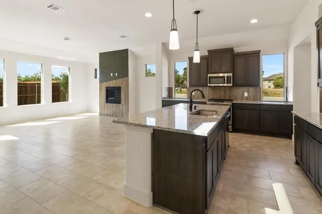 a kitchen with kitchen island granite countertop a sink counter top space and appliances