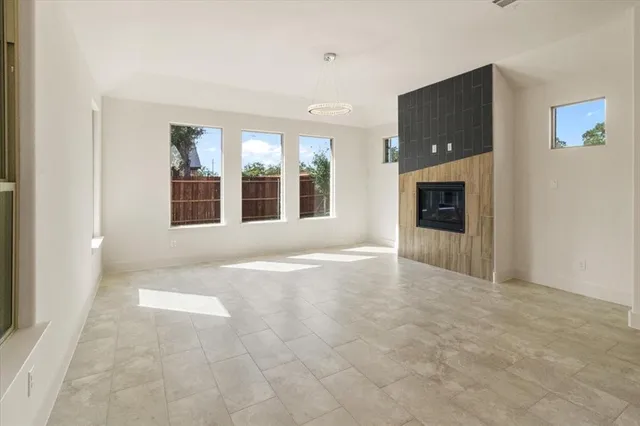 an empty room with windows and fireplace