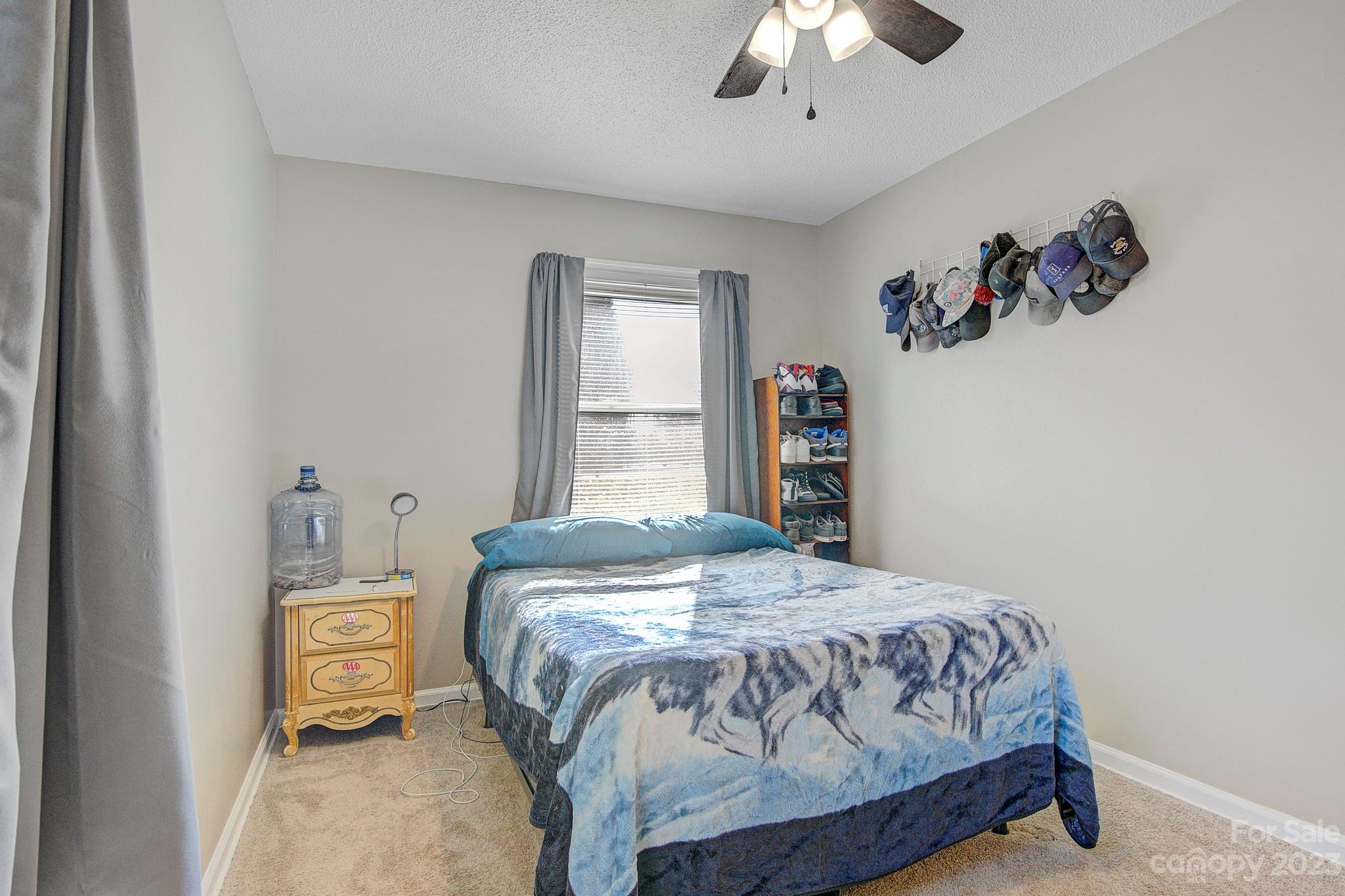 300 Newsome Road Salisbury, NC 28146 - Photo 17 of 27 a bedroom with a bed and a chandelier