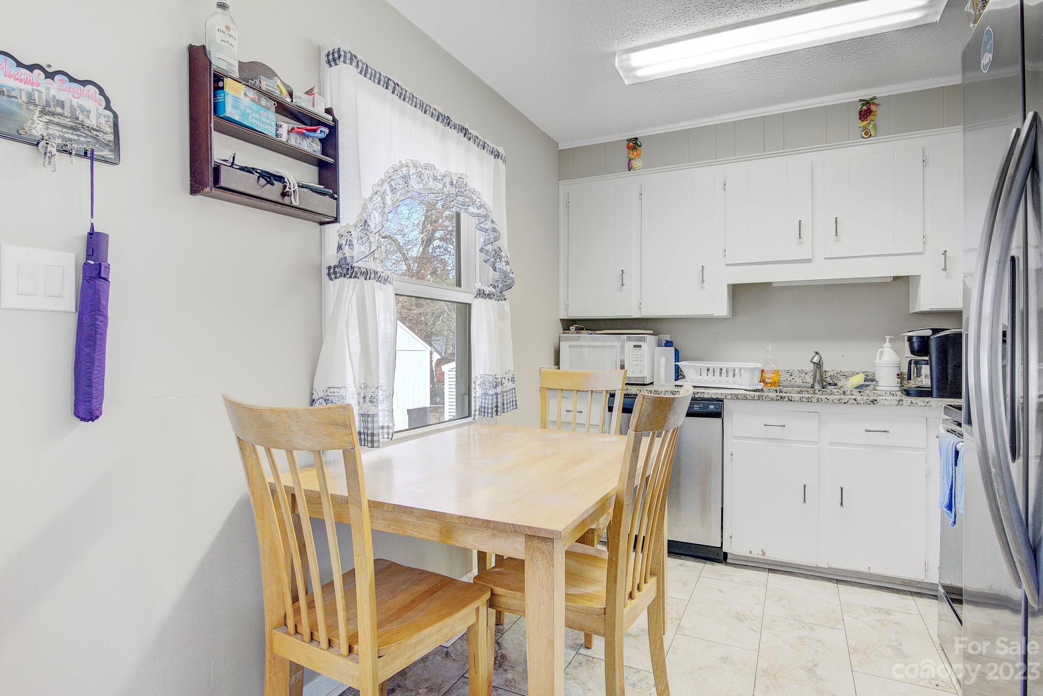 300 Newsome Road Salisbury, NC 28146 - Photo 25 of 27 a kitchen with stainless steel appliances granite countertop a stove a refrigerator a sink a dining table and chairs with wooden floor