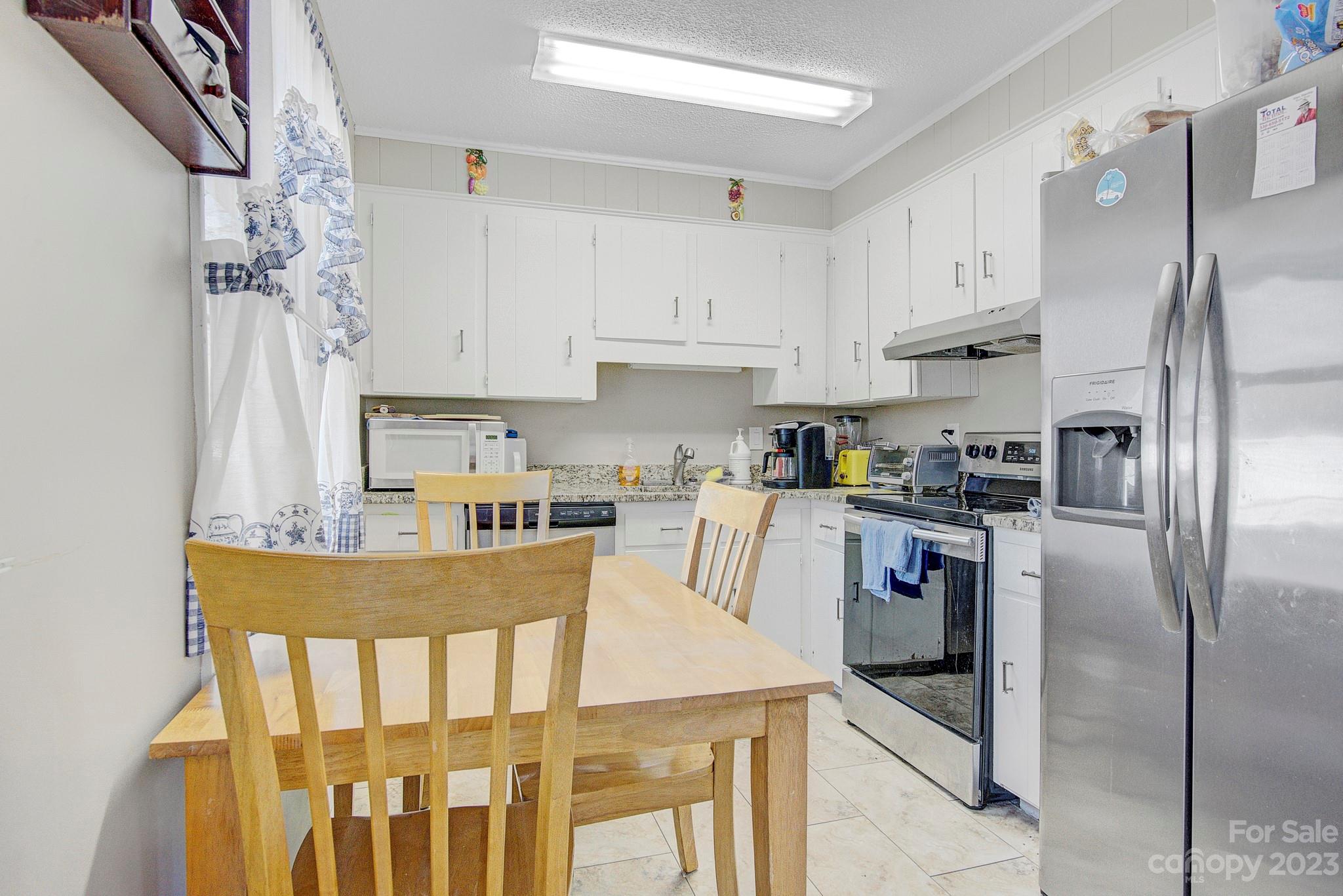 300 Newsome Road Salisbury, NC 28146 - Photo 26 of 27 a kitchen with stainless steel appliances granite countertop a refrigerator a stove a sink dishwasher and white cabinets with wooden floor