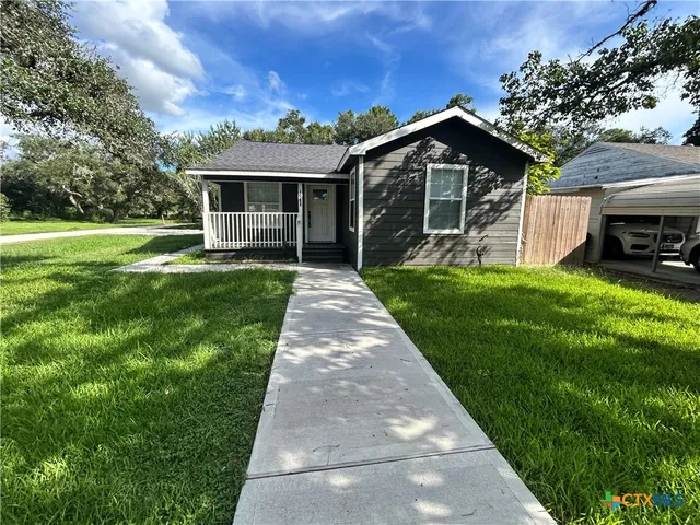 a front view of a house with a garden and porch