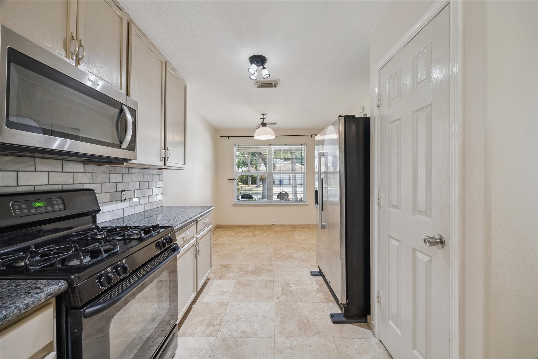 17610 Prospect Meadows Drive Houston, TX 77095 - Photo 11 of 33 a kitchen with stainless steel appliances granite countertop a stove top oven a sink dishwasher a refrigerator and a microwave