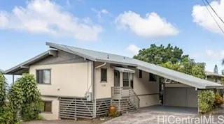 a front view of a house with plants