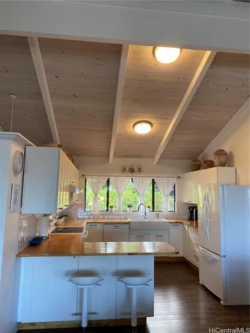a kitchen with stainless steel appliances wooden floor and large windows
