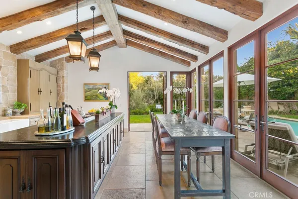 a dining hall with stainless steel appliances granite countertop a sink a stove and a wooden floors