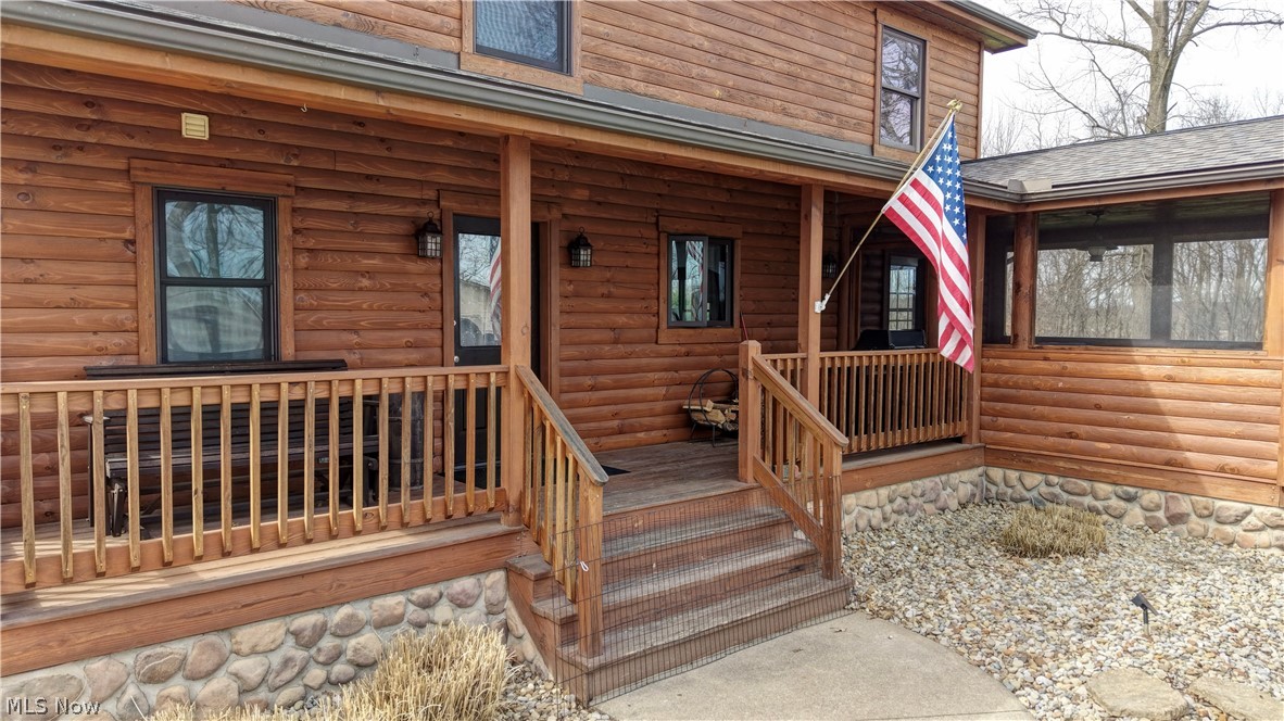 8045 McFadden Road Shreve, OH 44676 - Photo 22 of 45 Doorway to property featuring faux log siding, a porch, and roof with shingles