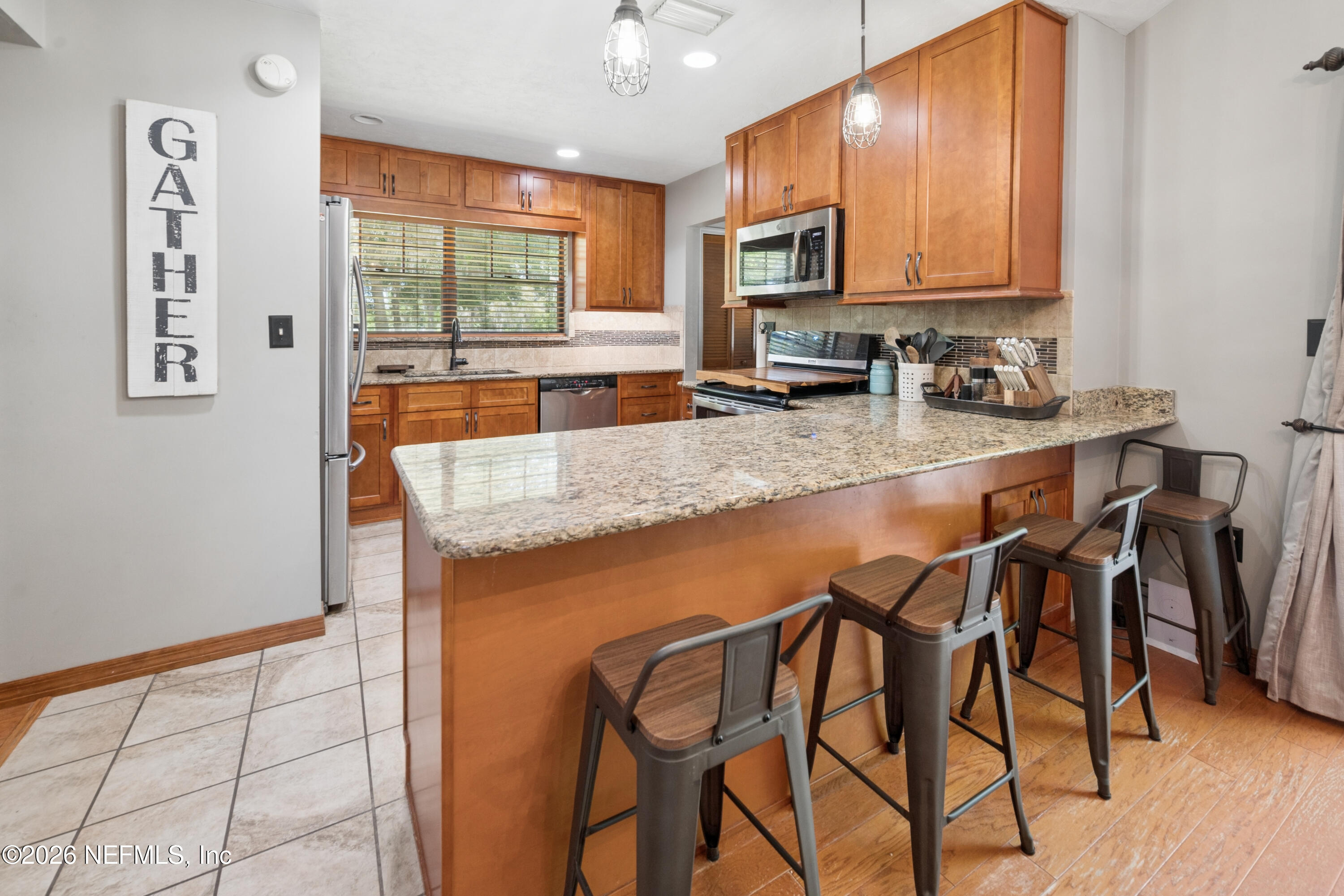 6519 Neale Road Melrose, FL 32666 - Photo 17 of 48 a kitchen with stainless steel appliances granite countertop a stove top oven a sink a dining table and chairs with wooden floor