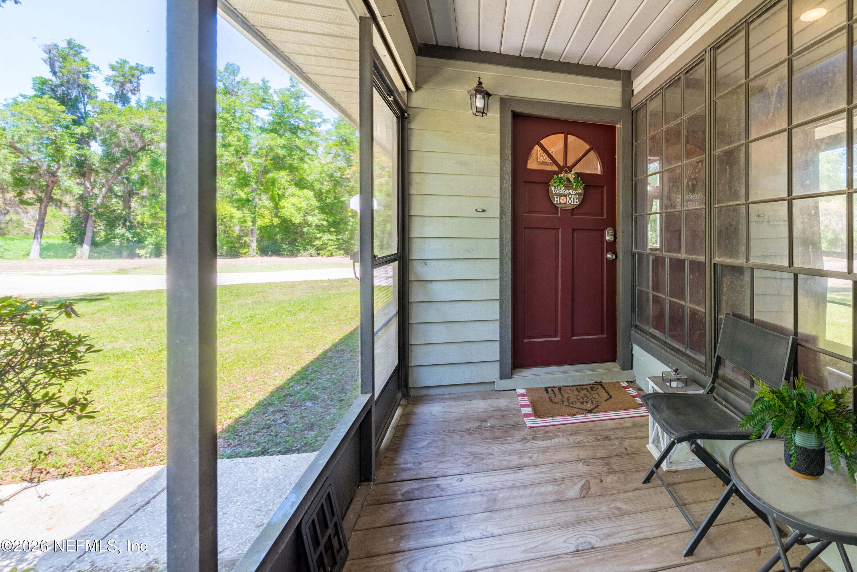 6519 Neale Road Melrose, FL 32666 - Photo 9 of 48 a view of a porch with a table and chairs next to a yard