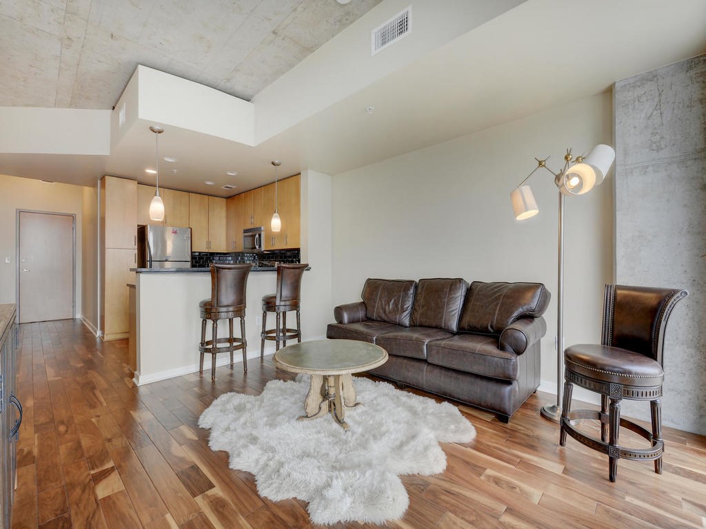 360 Nueces Street, Unit 2607 Austin, TX 78701 - Photo 1 of 1 a living room with furniture and a dining table with wooden floor