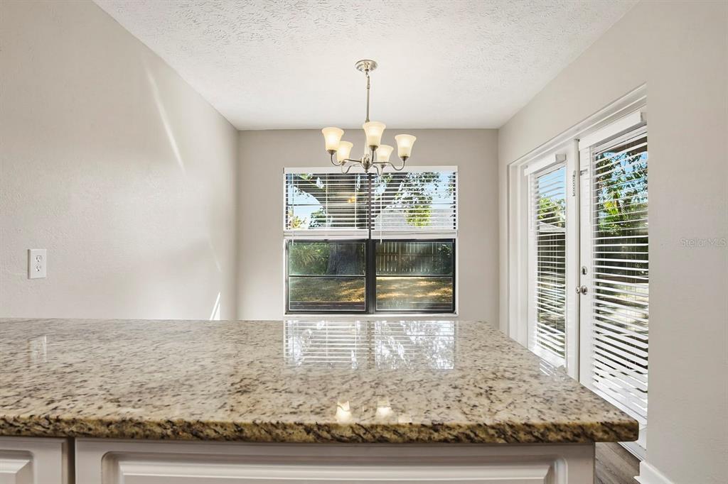 15009 Naples Place Tampa, FL 33624 - Photo 21 of 42 a view of a livingroom with wooden floor a chandelier and windows