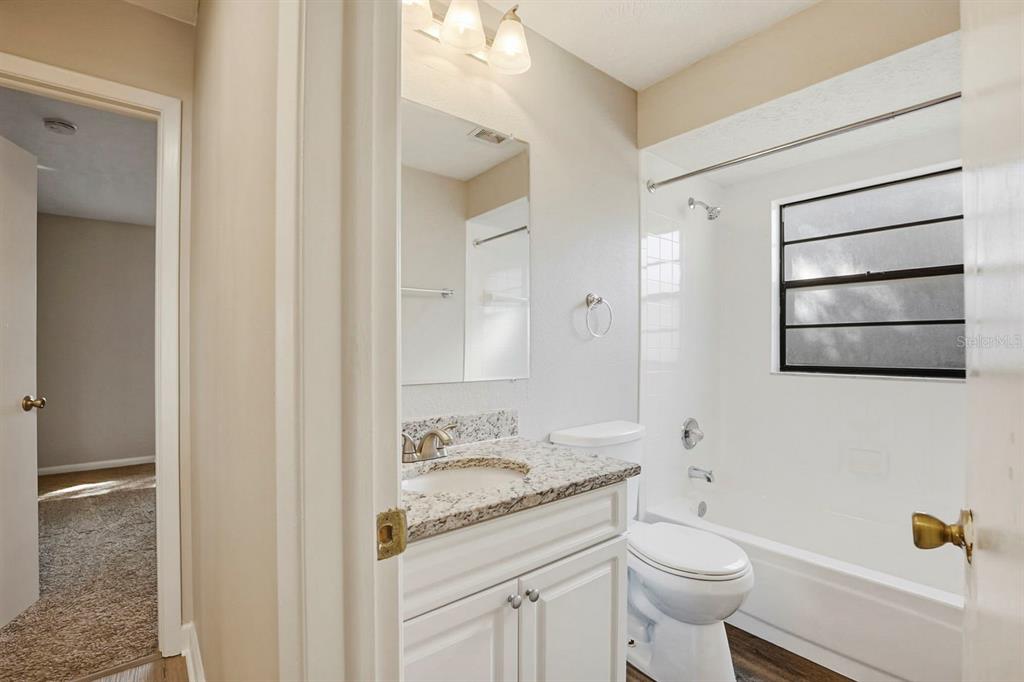 15009 Naples Place Tampa, FL 33624 - Photo 34 of 42 a bathroom with a granite countertop sink toilet and shower