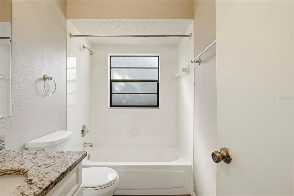 15009 Naples Place Tampa, FL 33624 - Photo 35 of 42 a bathroom with a granite countertop sink toilet and shower
