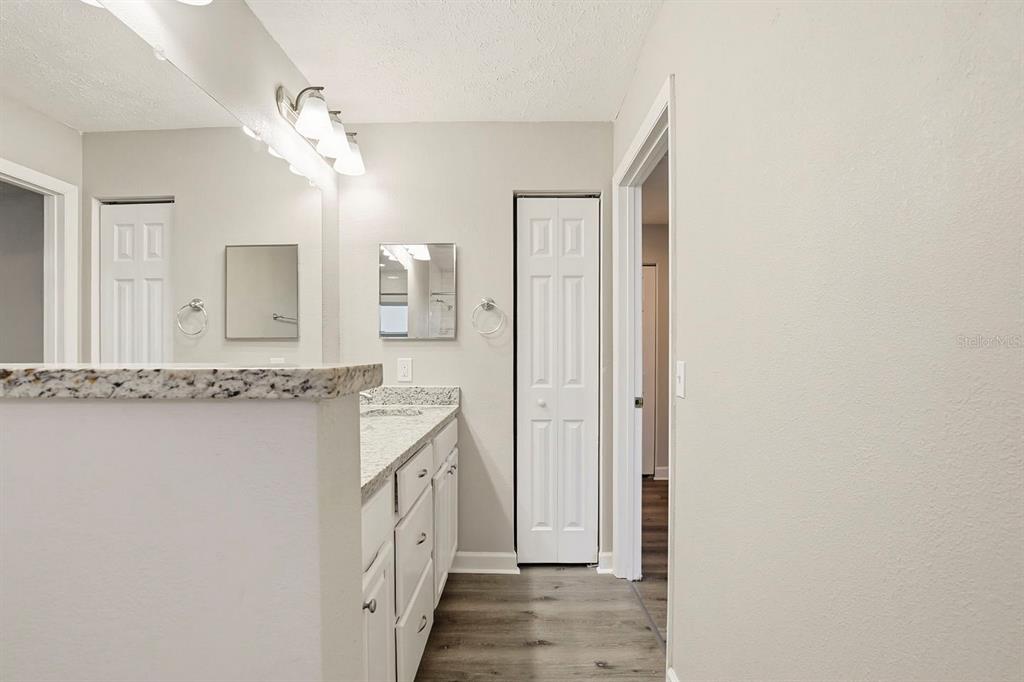 15009 Naples Place Tampa, FL 33624 - Photo 36 of 42 a bathroom with a granite countertop sink a mirror and a shower