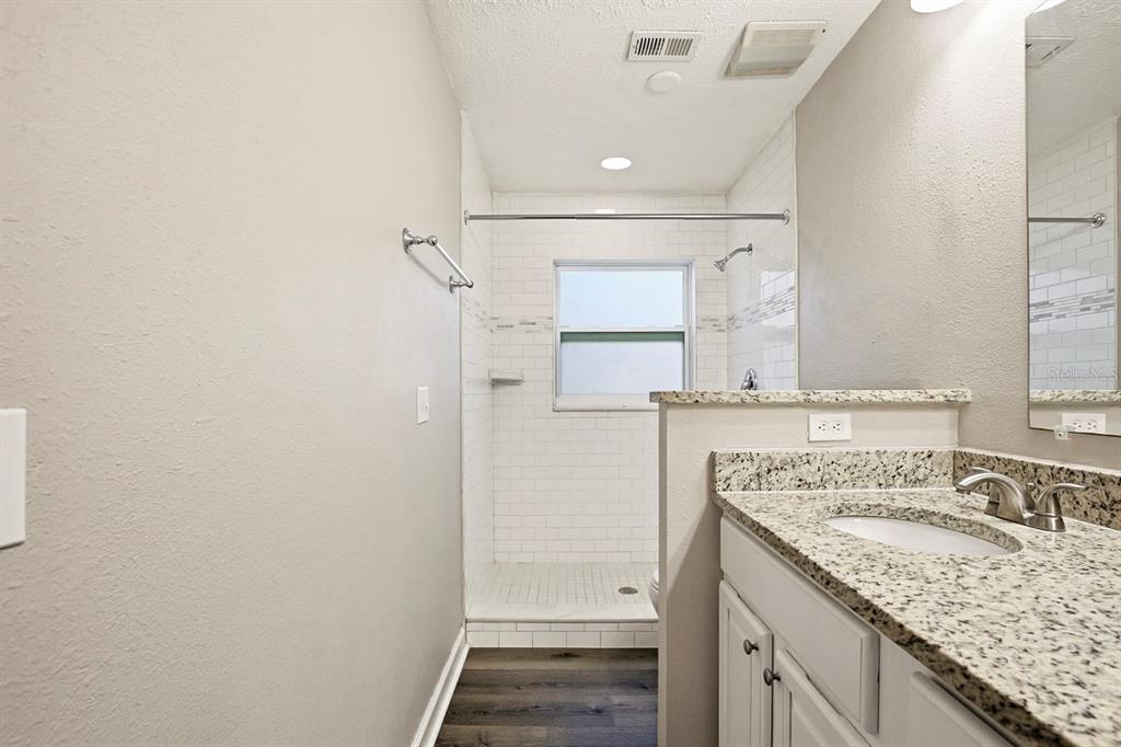 15009 Naples Place Tampa, FL 33624 - Photo 37 of 42 a bathroom with a granite countertop sink and a mirror