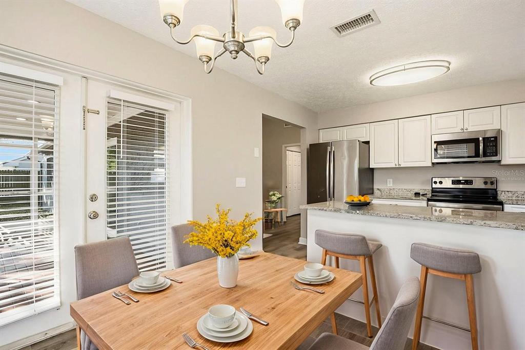 15009 Naples Place Tampa, FL 33624 - Photo 5 of 42 a view of a dining room with furniture a chandelier and wooden floor