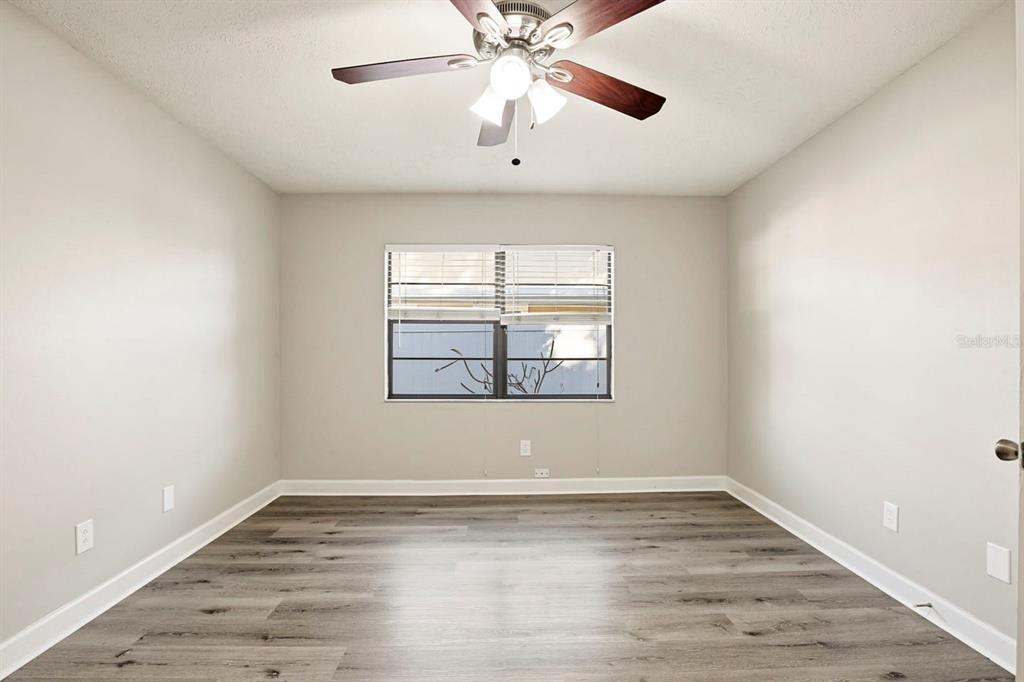 15009 Naples Place Tampa, FL 33624 - Photo 8 of 42 a view of empty room with wooden floor and fan