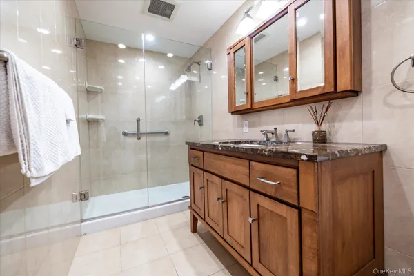 a bathroom with double vanity and a mirror