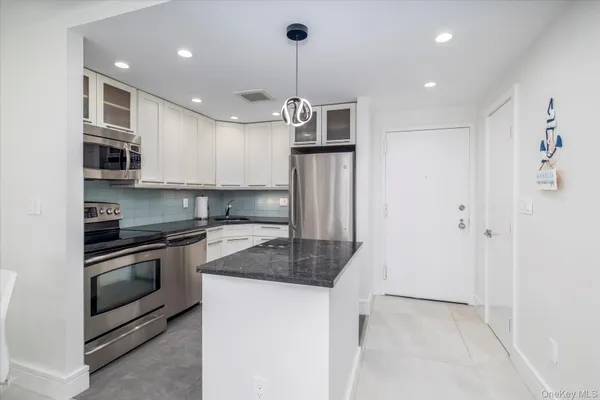 a kitchen with stainless steel appliances granite countertop a sink a stove and a refrigerator